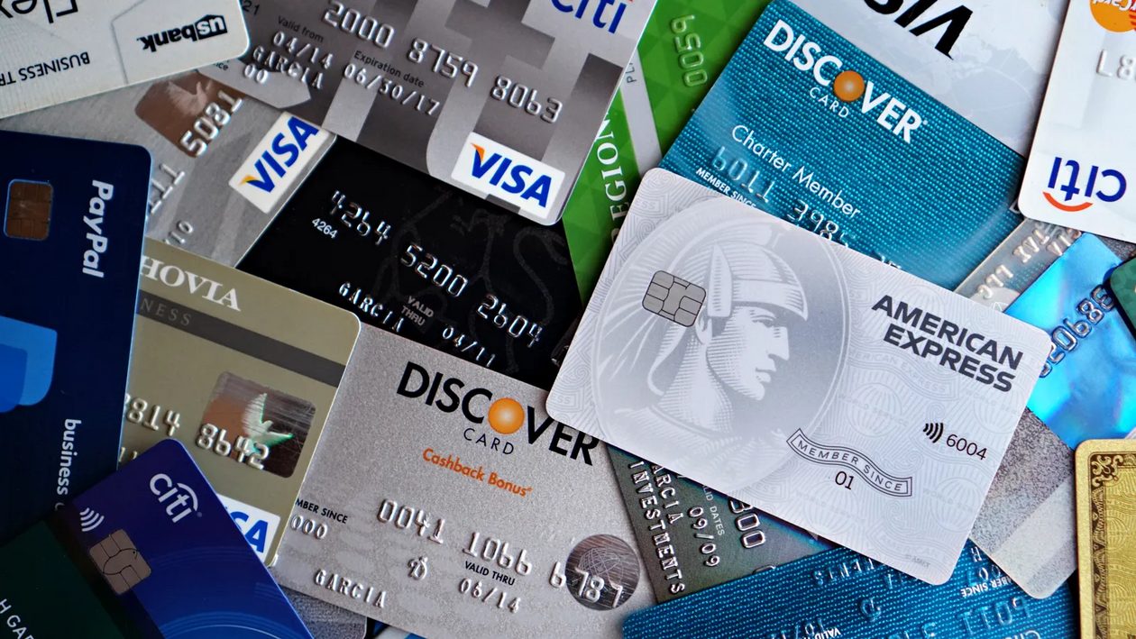 A pile of credit cards from different issuers spread across a table