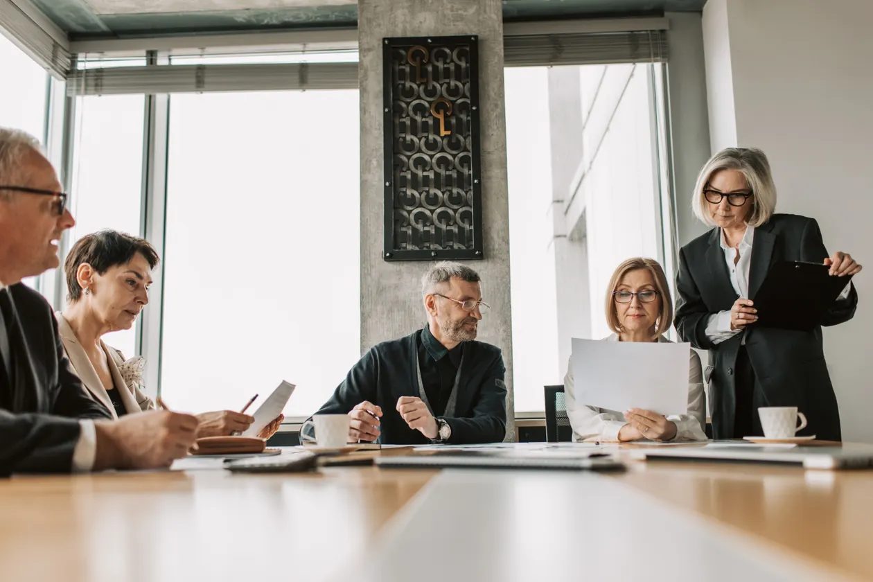 Colleagues in a bright boardroom discussing a workplace retirement plan